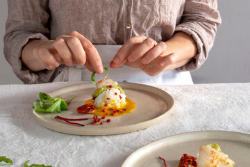 Obraz na płótnie Canvas A woman prepares a gastronomic dish at home or in a restaurant
