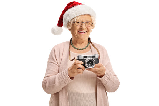Elderly lady with a vintage camera wearing a santa claus hat