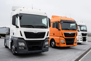 Trucks stand in a row at a truck stop. Close-up. Cargo semi-trailers for delivery and loading of cargo, logistics, cargo transportation