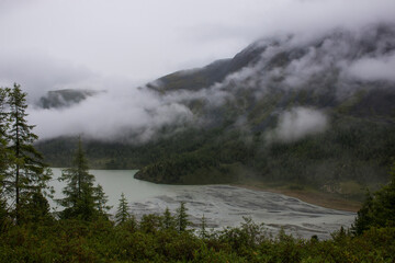 Obraz premium high mountain lake Akkem with mountains shrouded in clouds