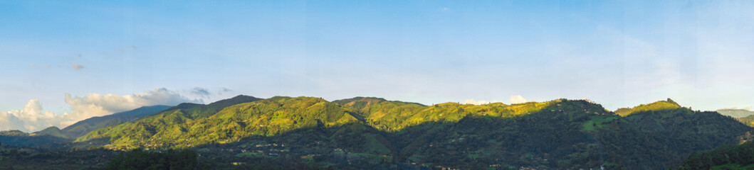 Green Mountain panorama 
bathed by the sun with clear blue sky in Andes