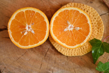 Fresh orange cut in half on a natural wood base