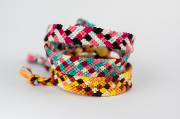 Fototapeta premium Group of handmade homemade colorful natural woven bracelets of friendship isolated on white background