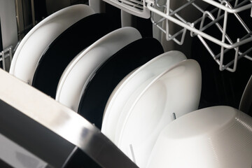 black and white dishes in the dishwasher compartment, close-up, top view