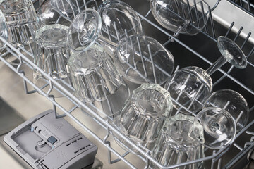 transparent glass goblets in the dishwasher compartment, close-up top view