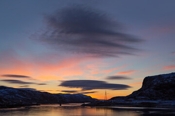 Beautiful bright sunrise over the river. Formation of a lenticular cloud. Landscape photography.