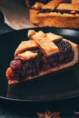 Freshly baked homemade pie with berries on a black background.