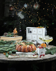 Christmas and new year. Christmas cake on a wooden table, gifts, books, fir branches, cones, drinks and snow. Background image, ñopy space, vertical