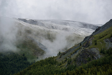 Altai mountains shrouded in white clouds, it looks quite gloomy