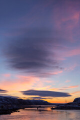 Beautiful bright sunrise over the river. Formation of a lenticular cloud. Landscape photography.