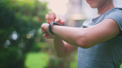 Close up fitness woman hands is touching her smart watch fitness technology concept. - Powered by Adobe