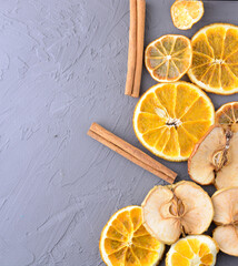 dried orange and cinnamon slices on gray wooden background. concept of meeting new year and christmas.