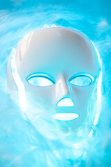 Led mask glowing blue on foggy background