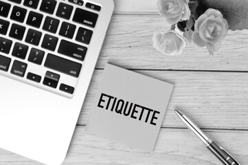 Black and white picture of laptop, pen, flowers and memo note written with text ETIQUETTE. Business...