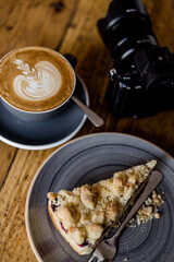 Cup of hot Cappuccino coffee on wooden table at cafe. with Cake Fresh invigorating drink with camera
