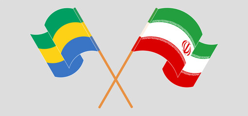 Crossed and waving flags of Gabon and Iran