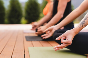 Cropped shot of people`s hands while meditation outdoors