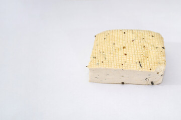 piece of tofu cheese on a white background.