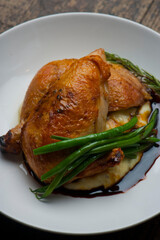 Chicken pan seared in garlic, butter, shallots and white wine. Classic fine dining cuisine. Served with steamed vegetables, broccoli carrots cauliflower, garnished with lemons and Italian parsley.