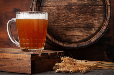 Mug of light lager beer and old wooden barrel