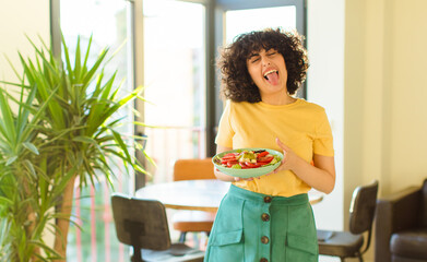 young pretty woman with cheerful, carefree, rebellious attitude, joking and sticking tongue out,...