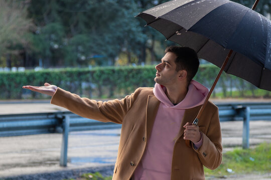 man with umbrella on the street checking if it rains