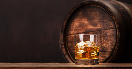 Scotch whiskey glass and old wooden barrel