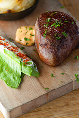 Steak and potatoes. Grade A grass fed angus beef steaks. Tenderloin, filet mignon, New York strip, bone in rib-eye grilled medium rare on outdoor wood-fired grill. Classic American steakhouse entree.