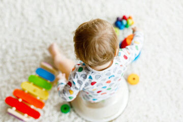 Closeup of cute little 12 months old toddler baby girl child sitting on potty.