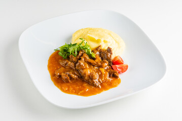 meat with mashed potato on the white plate