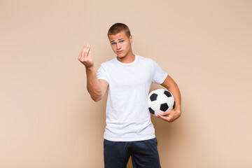 young blonde man making capice or money gesture, telling you to pay your debts!