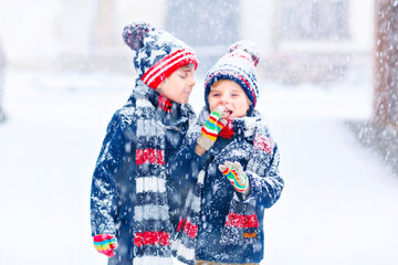 Happy children having fun with snow in winter
