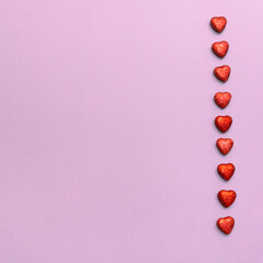 Valentine day background. Red hearts in a row on a pink background, copy space