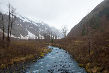 Fototapeta na wymiar Blue river in the snow covered mountains in Alaska