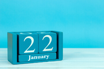 wooden calendar with the date of December 22 on a blue wooden background