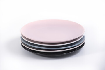 Stack of five colorful empty plates isolated on white background, side view. Pink, White, Navy Blue, Grey and Black empty plates collection