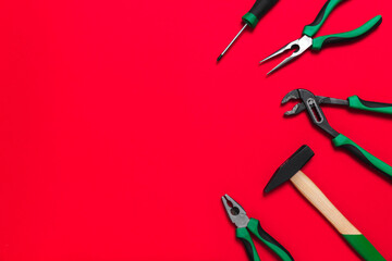 A set of quality green building tools to repair a car or a house on a red background. Do it yourself instruments. Banner for advertising construction shop with copy space. Business card