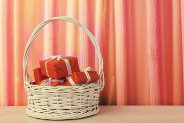 Fototapeta na wymiar Red gift boxes in handmade white basket