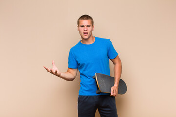young blonde man looking angry, annoyed and frustrated screaming wtf or what’s wrong with you