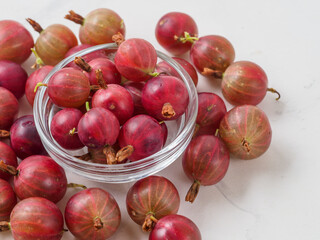 Fresh gooseberry on white wooden background.