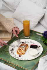 Woman reading book while having breakfast in bed.