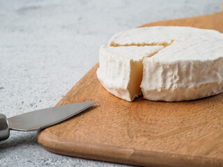 Traditional french cheese brie on wodden cutting board.