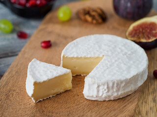 Traditional french cheese brie on wodden cutting board.