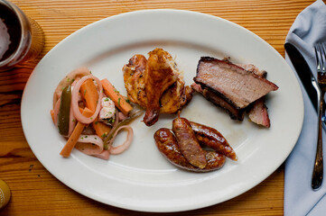 Barbecue catering platter with variety of meats. Traditional Texas BBQ: Beef brisket, beef ribs, pork ribs, sausage links, black pepper roasted chicken, and turkey served with homemade sauce.