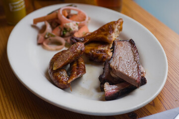 Barbecue catering platter with variety of meats. Traditional Texas BBQ: Beef brisket, beef ribs, pork ribs, sausage links, black pepper roasted chicken, and turkey served with homemade sauce.