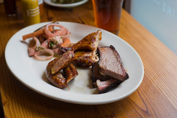 Barbecue catering platter with variety of meats. Traditional Texas BBQ: Beef brisket, beef ribs, pork ribs, sausage links, black pepper roasted chicken, and turkey served with homemade sauce.