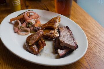 Barbecue catering platter with variety of meats. Traditional Texas BBQ: Beef brisket, beef ribs, pork ribs, sausage links, black pepper roasted chicken, and turkey served with homemade sauce.