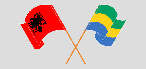 Crossed and waving flags of Albania and Gabon