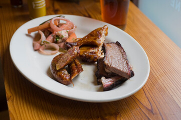 Barbecue catering platter with variety of meats. Traditional Texas BBQ: Beef brisket, beef ribs, pork ribs, sausage links, black pepper roasted chicken, and turkey served with homemade sauce.