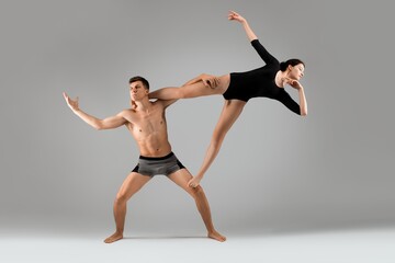 Fototapeta premium Graceful young couple doing gymnastic exercise together